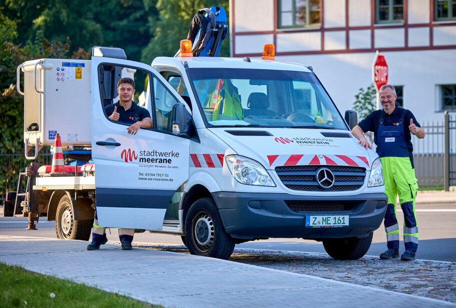 Baustellenfahrzeug mit zwei Mitarbeitern